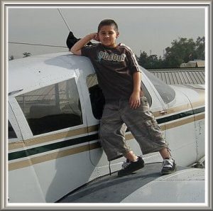 Grandson Omar standing on the wing of Jim's plane.