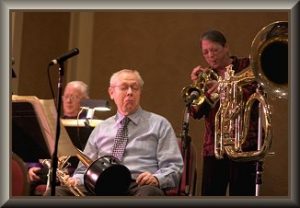 Jim playing bass trombone in a concert with the Roger Neumann Rather Large Band with my Fluba in the background and the late, great Stacy Rowles on Flugel Horn.